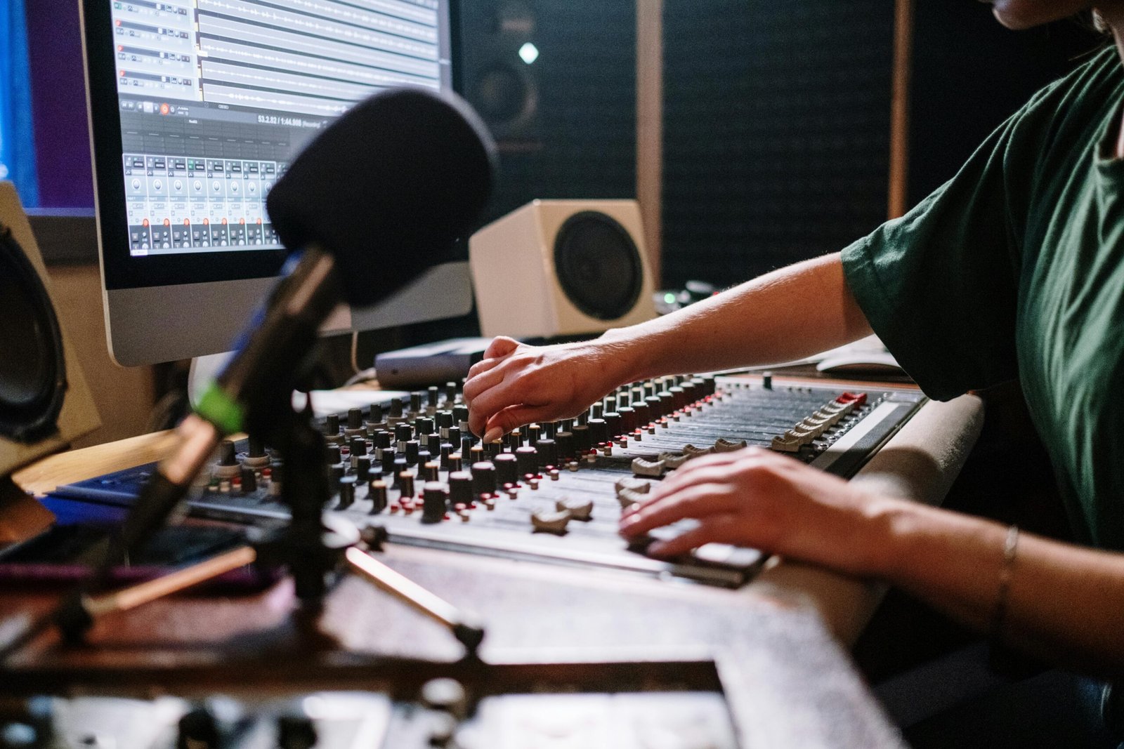 professional content creator speaking into microphone, streaming setup, engaging with audience, modern studio lighting